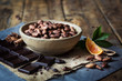 fave di cacao con cioccolato fondente, spezie e arancia su tavolo rustico in legno