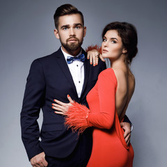 Wall Mural - Woman in beautiful red dress and man wearing blue classical suit with bow tie.