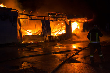 a garage on fire with flames coming thought the roof