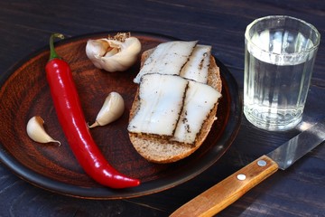 Poster - Sliced lard in a plate, garlic, vodka and red pepper