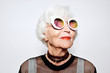 © Clique Images/Stocksy - Smiling senior woman in stylish sunglasses and shirt