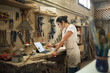 © Jelena Jojic Tomic/Stocksy - Furniture designer at the workshop working on a tablet