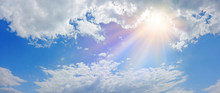 Miraculous Heavenly Light Panorama Banner -  Wide Blue Sky, Fluffy Clouds And A Beautiful Warm Orange Yellow Sun Beaming Down Radiating Depicting A Holy Entity 
