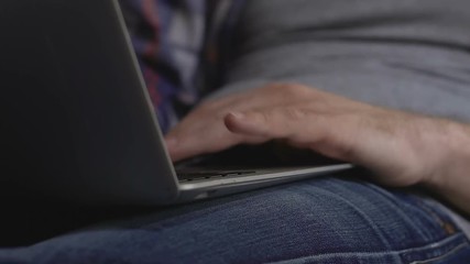 Male hands scrolling laptop touchpad, surfing internet at home, freelance work