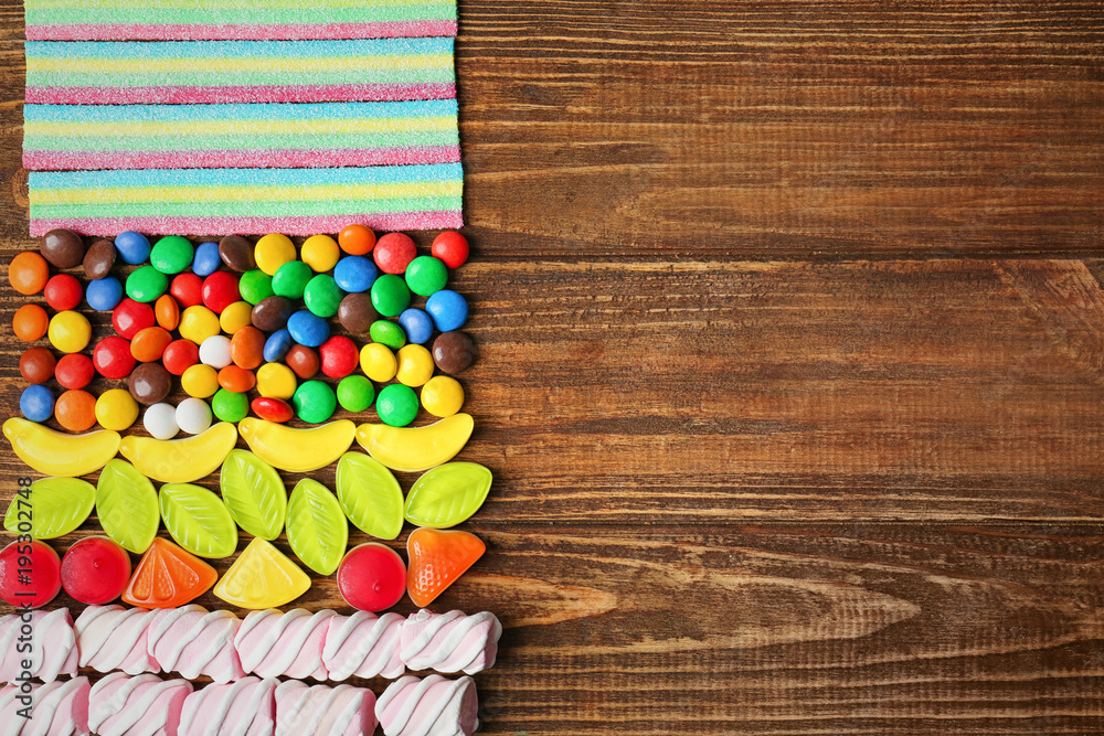 Colorful candies on wooden background