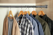 © Africa Studio - Hangers with different clothes in wardrobe closet