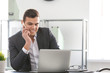 © Africa Studio - Young man in office wear talking on phone at workplace