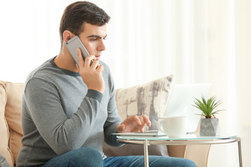 Canvas Print - Young man working with laptop in home office