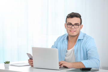 Sticker - Young man working with laptop at table in home office