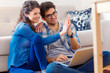 © Zoran Zeremski - Smiling young couple shopping online over the laptop in their home.