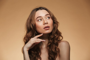 Sticker - Beauty portrait of half naked thoughtful woman 20s with auburn hair looking aside with interest, isolated over beige background