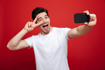 Wall Mural - Portrait of an excited young man in white t-shirt