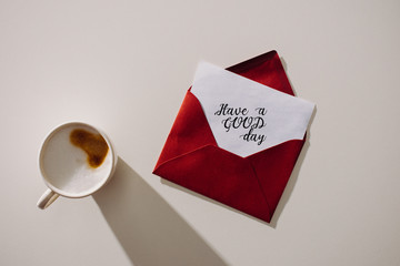 Wall Mural - top view of red envelope with have a good day lettering lettering on paper paper and cup of coffee