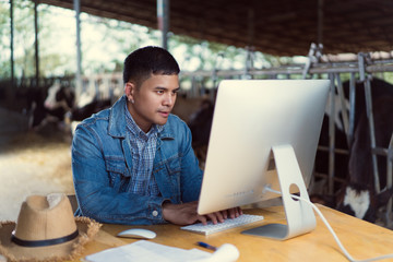 farmer is using the computer for farm information. to sell milk online