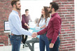© ASDF - Smiling businessman shaking hands with colleague in office.