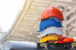 Stack of engineer safety helmet and building blueprint lay on nearly construction area, engineer equipment and tool for work.