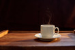 Чашка кофе на деревянном коричневом фоне в лучах солнца