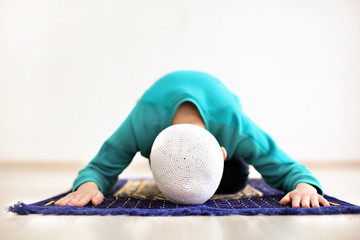 Wall Mural - Little Muslim boy praying, indoors