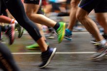 Male And Female Runner's Legs On Asphalt. Marathon