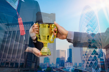 Double exposure photo.  Photo mix  building city and give a trophy. She is celebration education graduation . She is happy in good time. beside  building background.