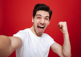 Wall Mural - Portrait of a joyful young man in white t-shirt