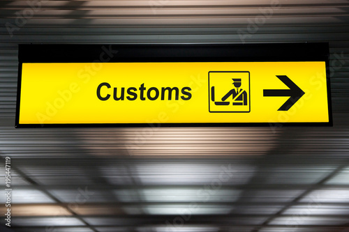 Cuadros en Lienzo airport customs declare sign with icon and arrow hanging from airport ceiling at international terminal