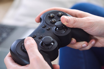 Canvas Print - man holding a joystick controllers while playing a video games at home