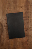 Fototapeta Desenie - An overhead photo mockup of a black book with a place for text