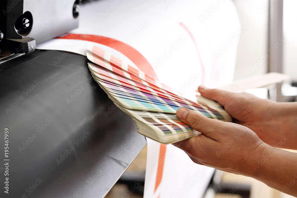 Drukarz sprawdza kolor wydruku na próbniku kolorów. - obrazy, fototapety, plakaty 
