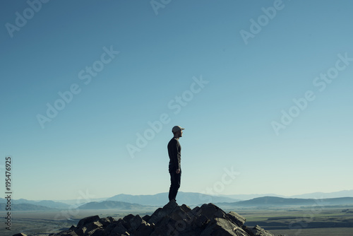 Fotografía Retrato de hombre a contraluz en la cima de una montaña rocosa