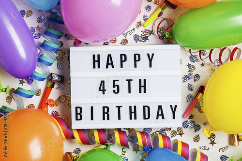 Happy 45th birthday celebration message on a lightbox with balloons and confetti Poster