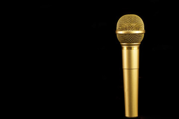 Golden microphone on black background.