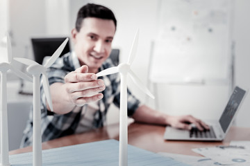 Wall Mural - It is just a model. Handsome brunette keeping smile on his face and putting left hand on the keyboard while looking at forward