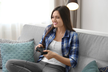 Wall Mural - Young woman playing video games at home