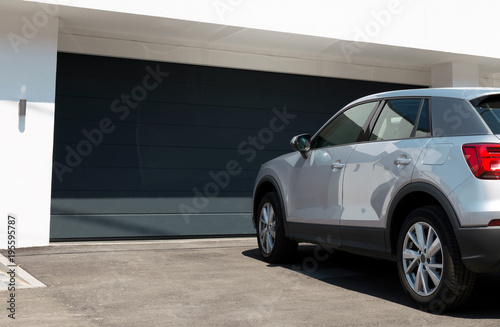 Cuadros en Lienzo Car in front of modern house waiting to enter in the garage with large garage do