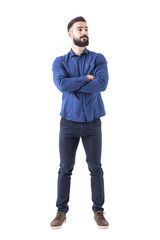 Wall Mural - Confident cool young bearded man standing and looking away with crossed hands. Full body isolated on white background. 