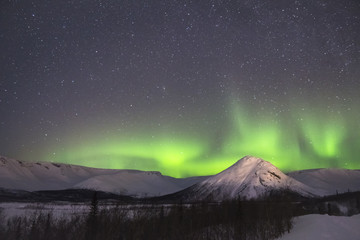 Wall Mural - Night Starry Sky and Green Northern Lights. Snow-Capped Mountains at Winter Night