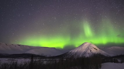 Wall Mural - Time Lapse of Night Starry Sky and Green Northern Lights in Snowy Mountains at Winter Night