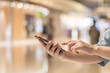© Chinnapong - Smartphone online shopping concept with woman's hands using mobile smart phone device with internet technology for digital city lifestyle in blur shopping mall