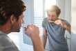 © Wavebreak Media - Man looking at mirror and brushing his teeth in bathroom