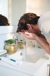 © Wavebreak Media - Man washing his face with water in bathroom