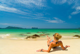 Fototapeta Łazienka - Young woman in bikini laying by the tropical sea