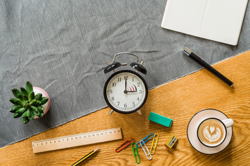 Wall Mural - switch to summer time on alarm clock with copyspace on notebook from above
