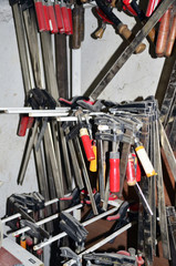 work table of a carpenter with many  tools olds hanging  in the background