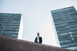 © Westend61 - Businessman standing in front of office towers