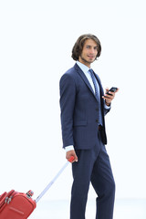 Wall Mural - handsome businessman with Luggage by typing SMS on the smartphone