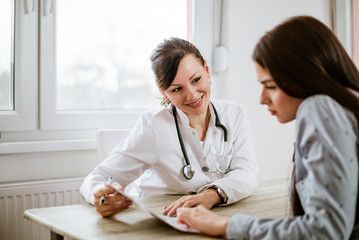 Charming female doctor giving good test results to a female patient.