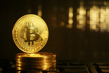 Golden coin of Bitcoin stand on stack coins with golden blur background.