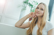 © My Ocean studio - Close up Portrait of a beautiful smiling young blond woman sitting at home on a sofa and resting or relaxing.