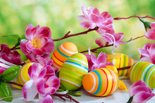 Easter. Still-life With Colored Eggs. Multicolored Eggs And A Cherry Branch On A Green Background.